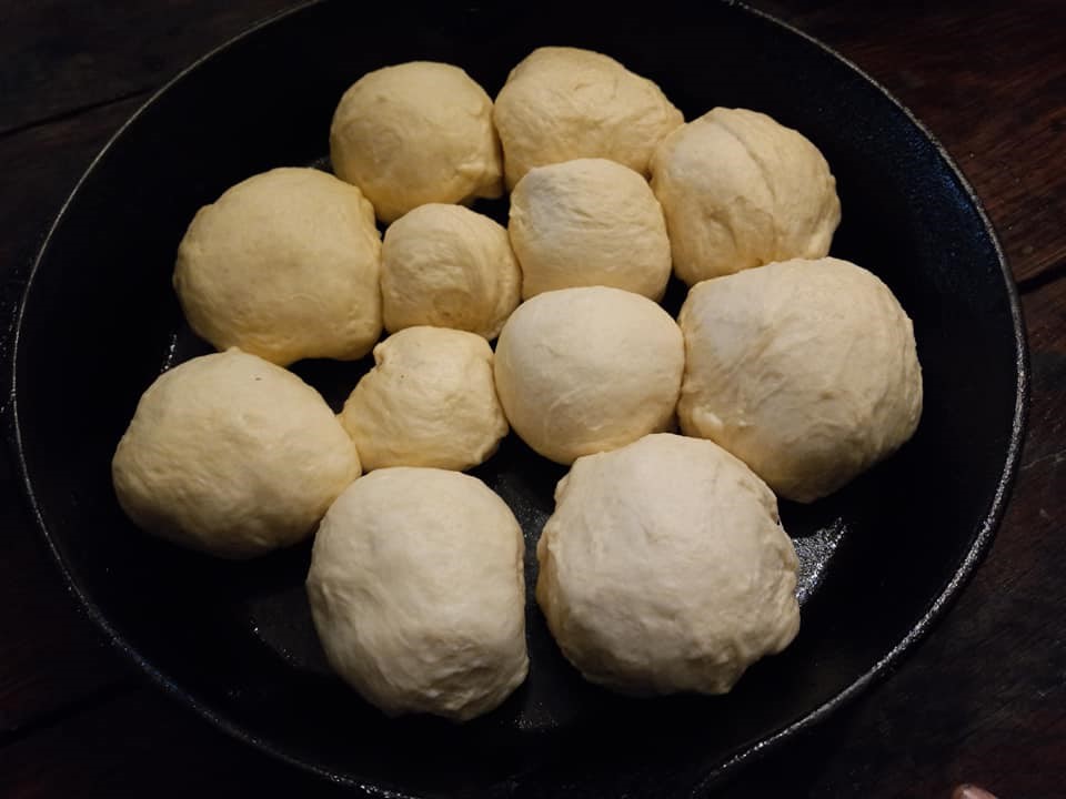 Homemade roll dough rising in a cast iron skillet