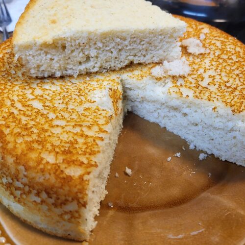 Southern-style skillet cornbread sliced on a brown plate with golden crust and fluffy inside