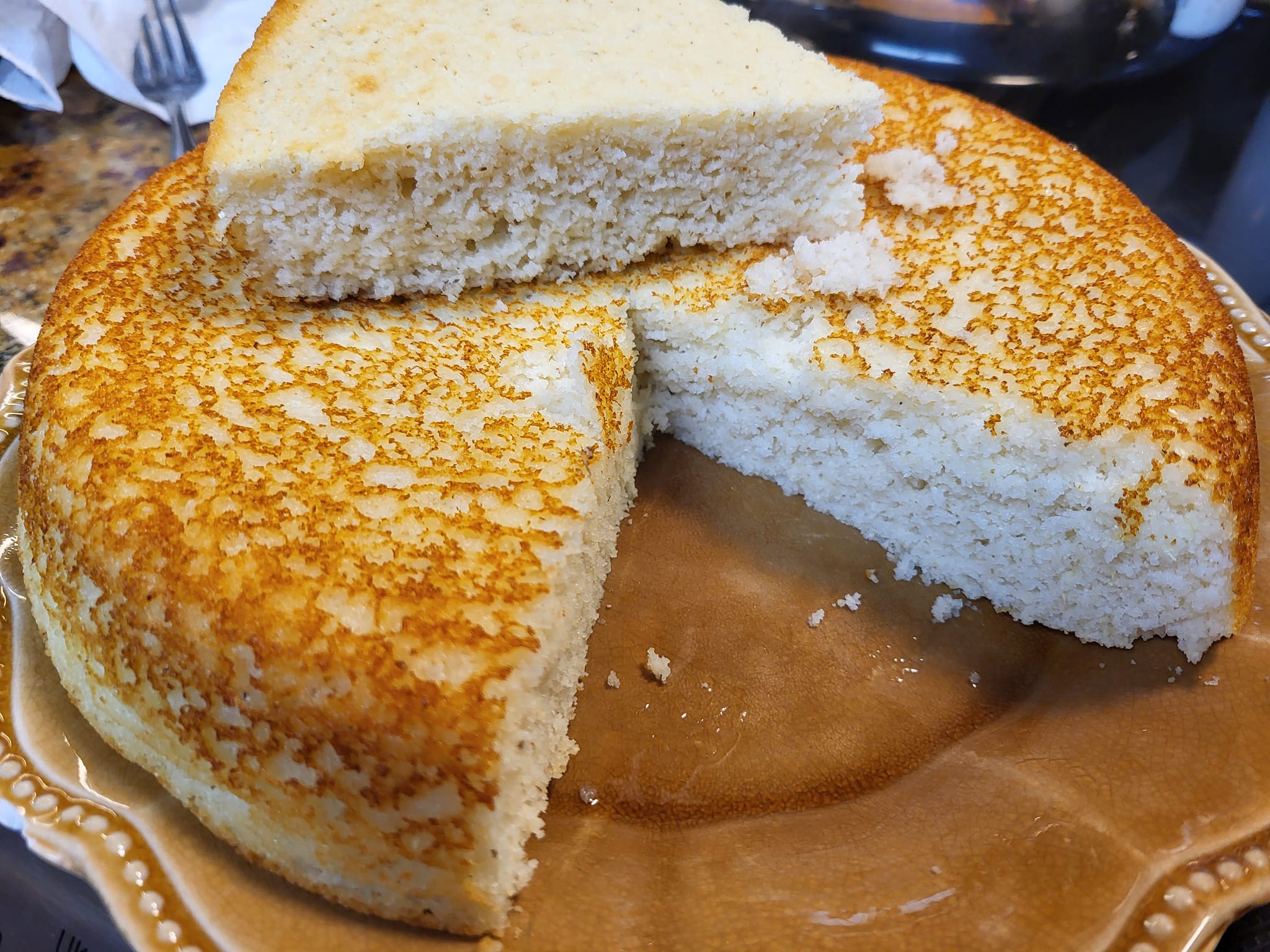 Southern-style skillet cornbread sliced on a brown plate with golden crust and fluffy inside