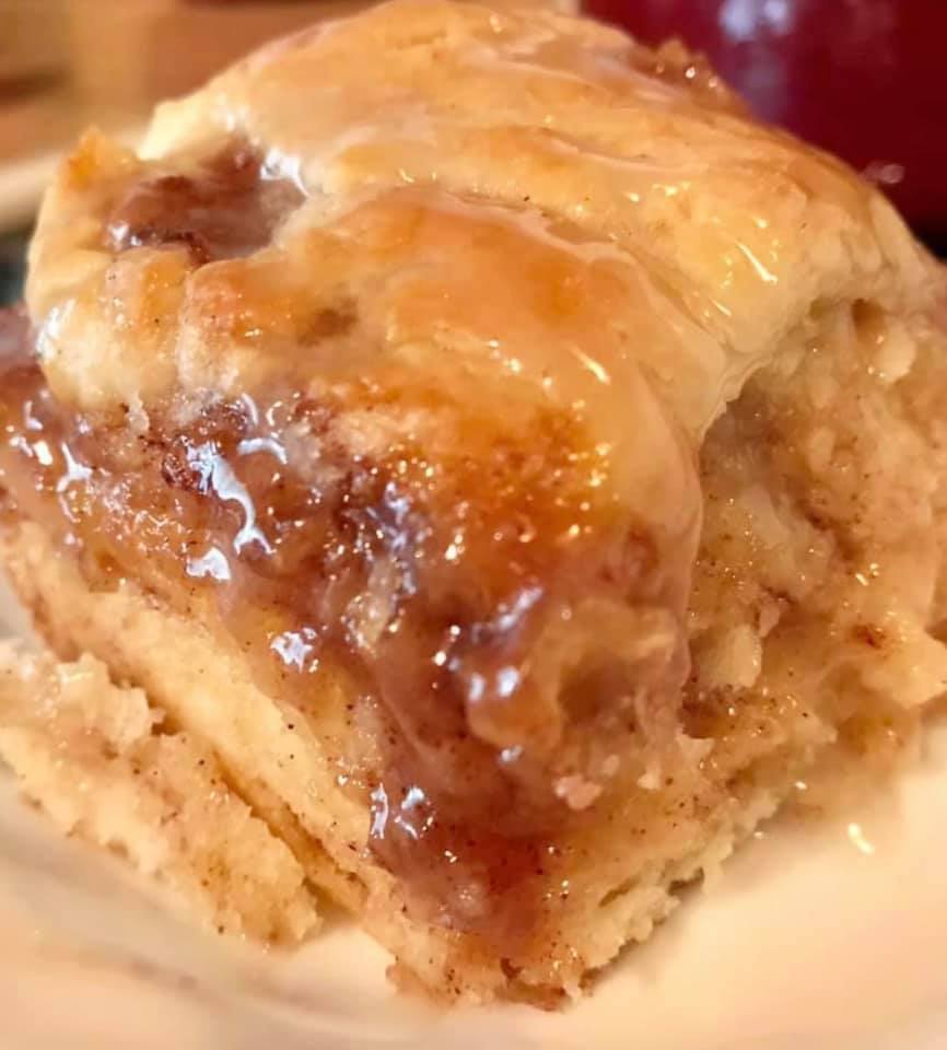 Close-up of cinnamon roll biscuit showing flaky layers and vanilla glaze.