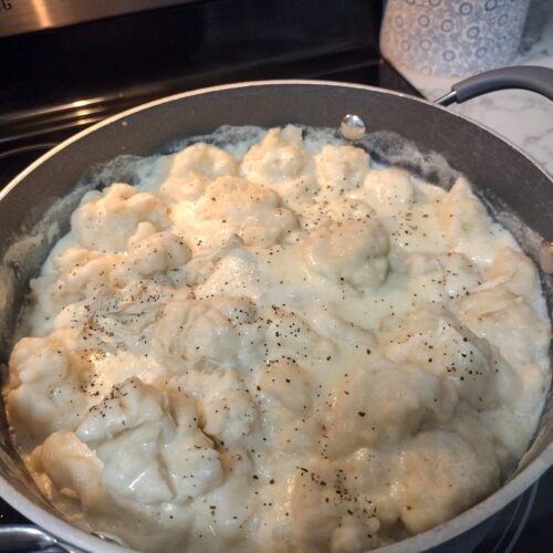 Old-fashioned chicken and dumplings simmering in a creamy broth with fluffy Bisquick dumplings