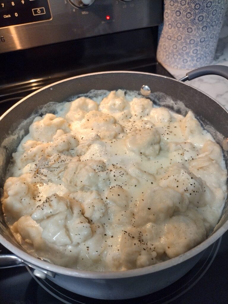 Old-fashioned chicken and dumplings simmering in a creamy broth with fluffy Bisquick dumplings