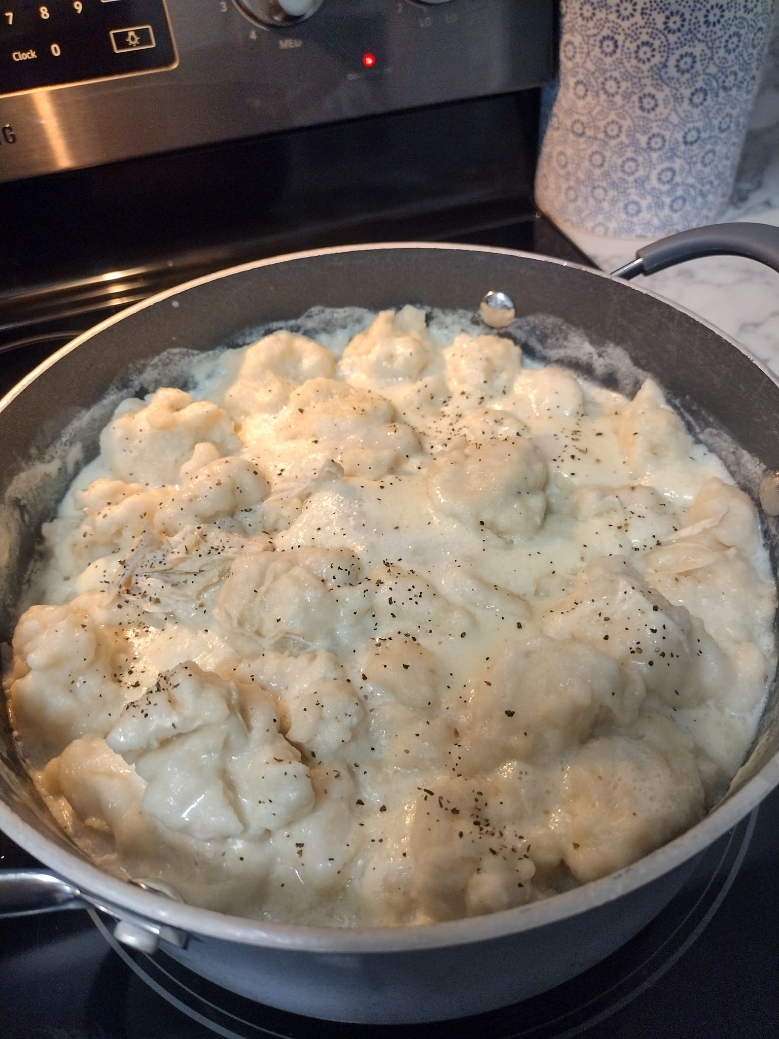 Old-fashioned chicken and dumplings simmering in a creamy broth with fluffy Bisquick dumplings