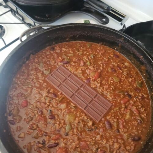 Rich chili bubbling in a pot with a chocolate bar melting in the center – an unexpected but delicious twist