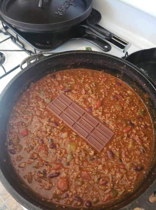 Rich chili bubbling in a pot with a chocolate bar melting in the center – an unexpected but delicious twist
