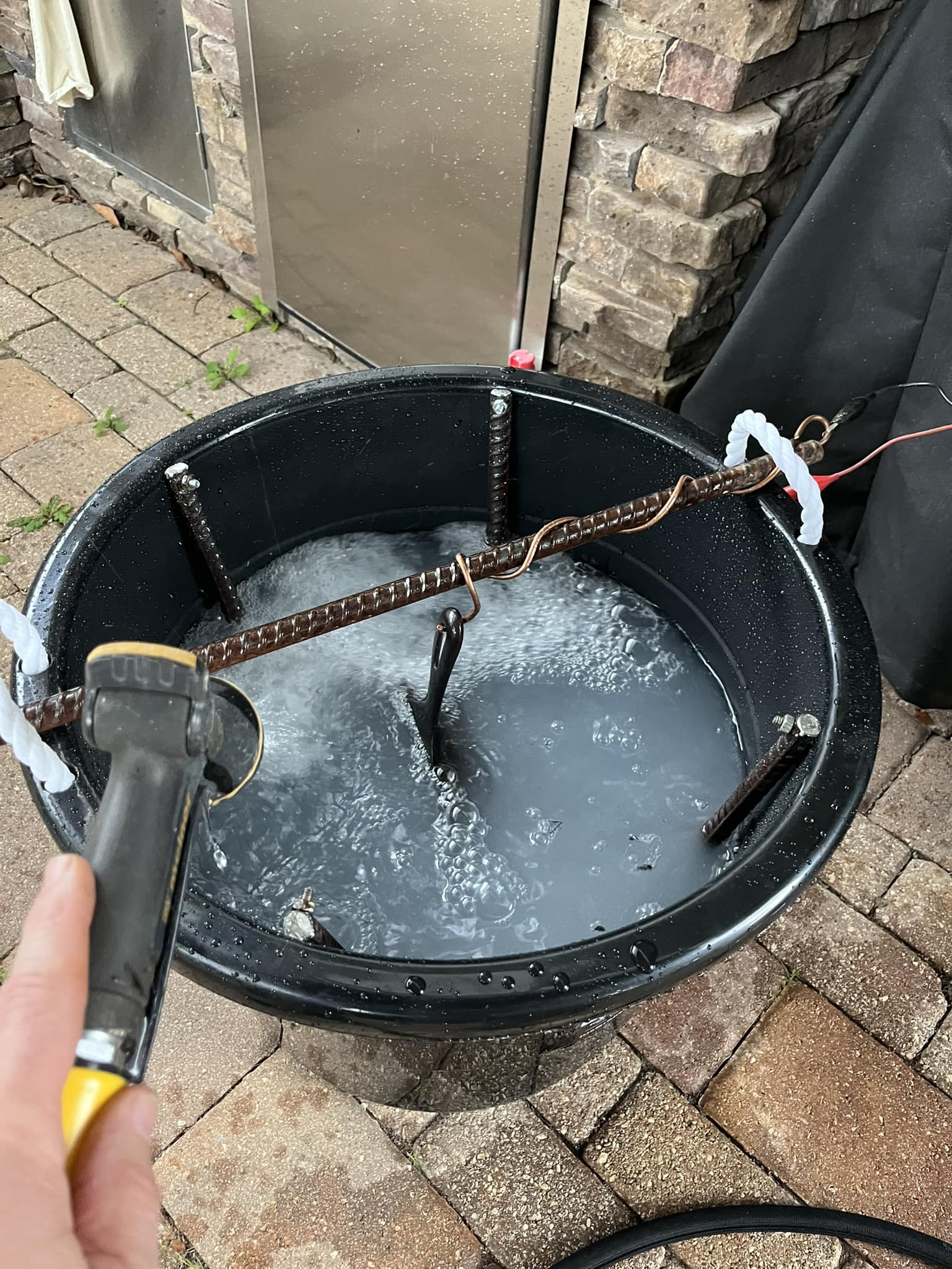 Filling the bucket with water and mixing in washing soda to create the electrolyte solution
