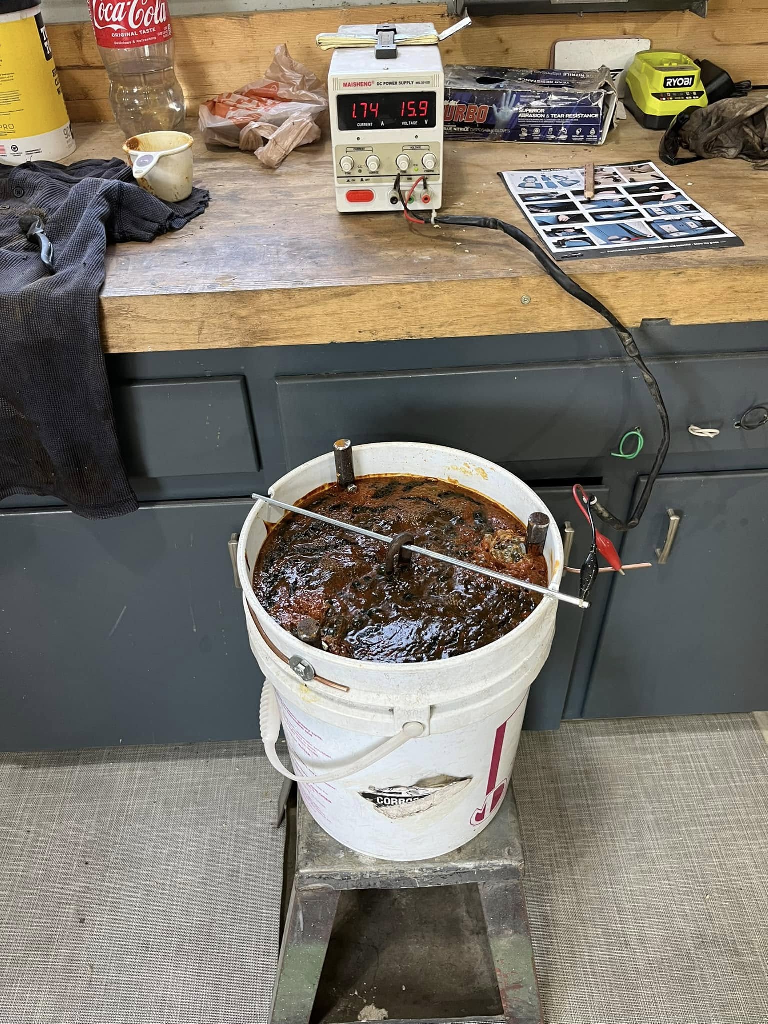 Electrolysis setup with cast iron pan suspended and power leads attached
