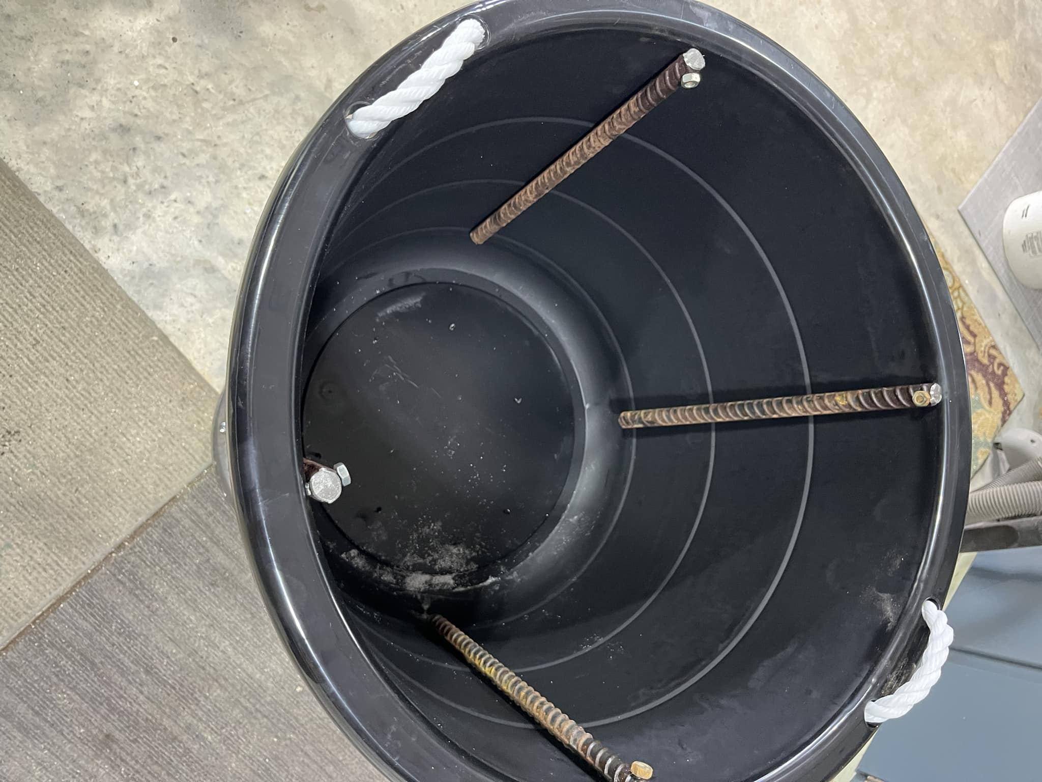 Setting up the electrolysis tank using a 5-gallon plastic bucket and four pieces of rebar as anodes. 
