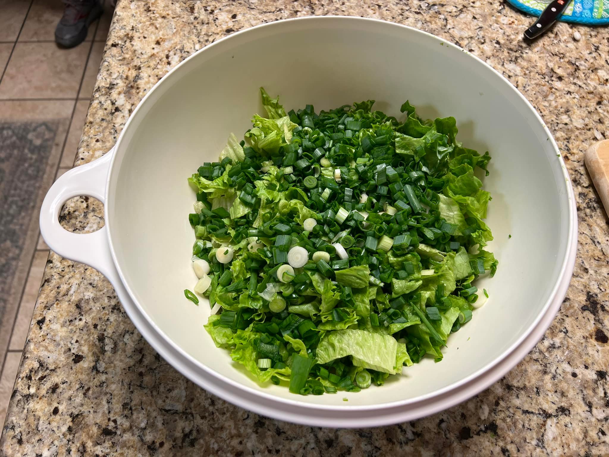 Empty white salad bowl with leftover green onion bits.