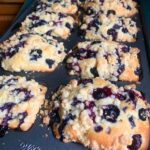 Golden blueberry muffin loaf with juicy berries and crunchy topping fresh out of the oven.