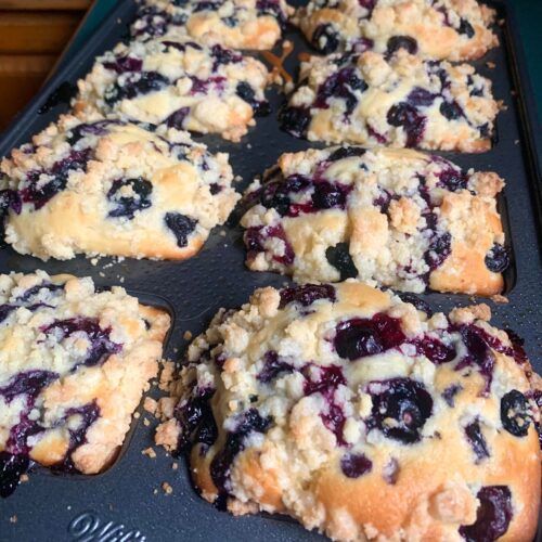 Golden blueberry muffin loaf with juicy berries and crunchy topping fresh out of the oven.