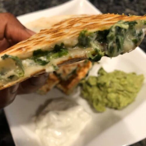 Stack of golden brown spinach dip quesadillas on plate