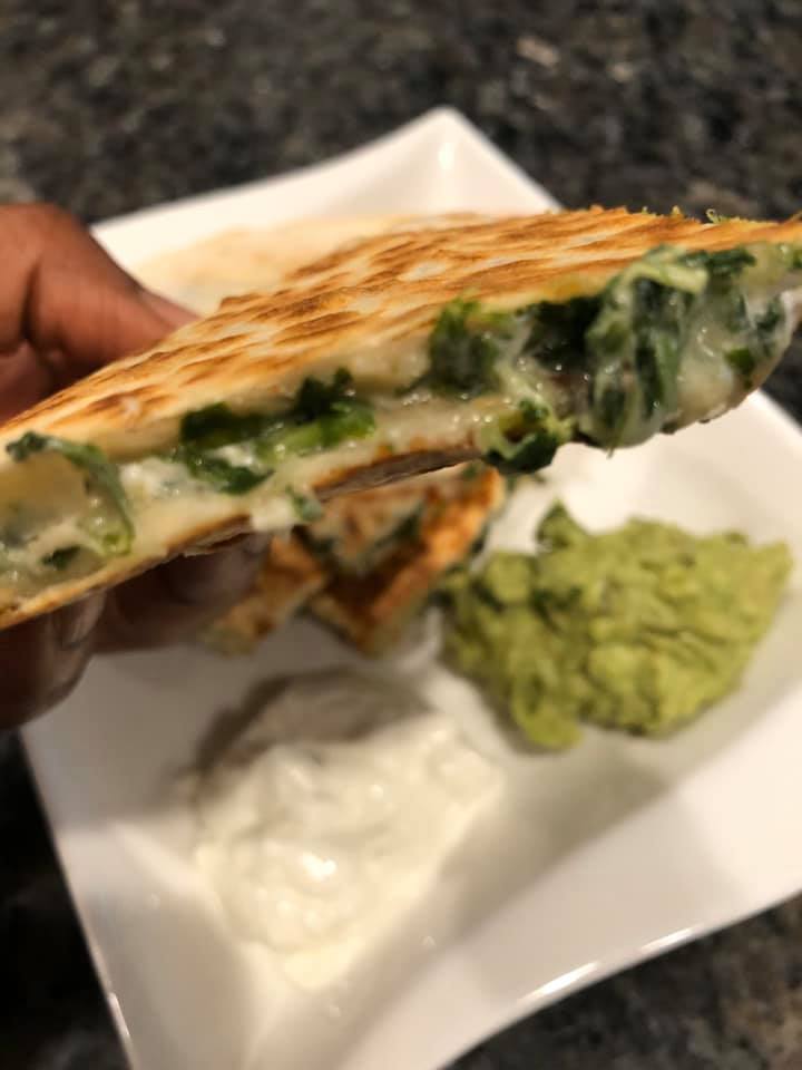 Stack of golden brown spinach dip quesadillas on plate