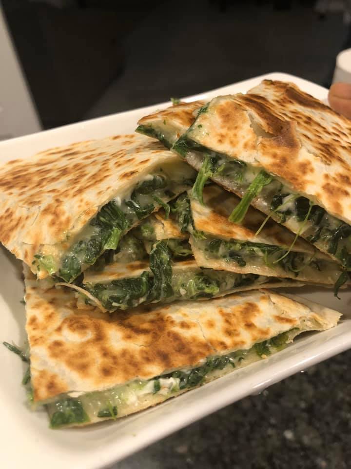 Crispy spinach dip quesadilla with sour cream and guacamole"