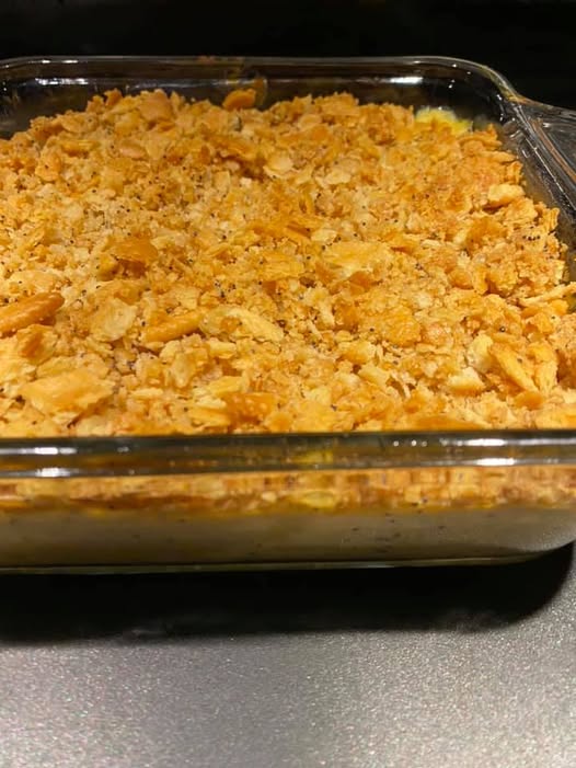 Baked poppy seed chicken casserole in a glass dish with golden Ritz cracker topping, ready to serve