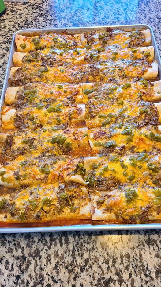 Baking dish filled with green chile pork enchiladas ready to serve.