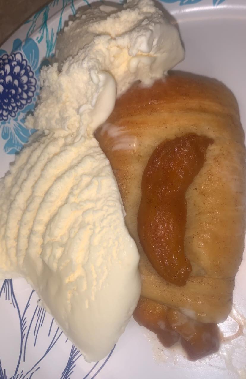 Warm peach biscuit turnover served with vanilla ice cream.