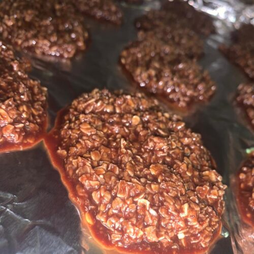 glossy no bake chocolate oatmeal cookies cooling on foil