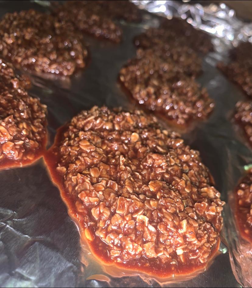 glossy no bake chocolate oatmeal cookies cooling on foil