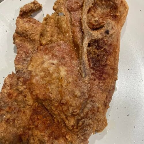 Crispy batter fried pork steak fresh from skillet