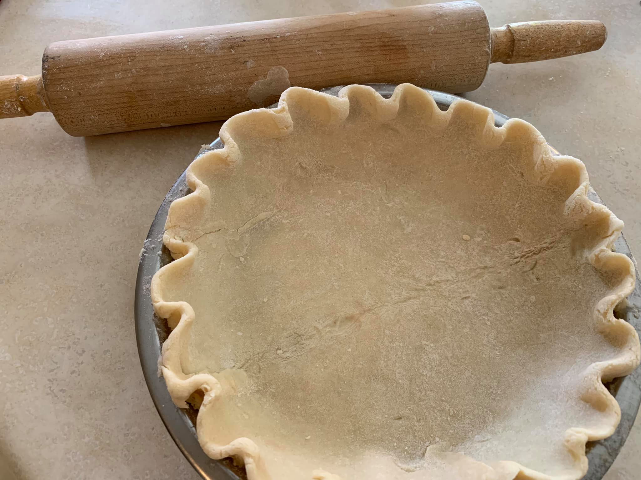 Homemade flaky pie crust crimped in pan, ready for chocolate filling