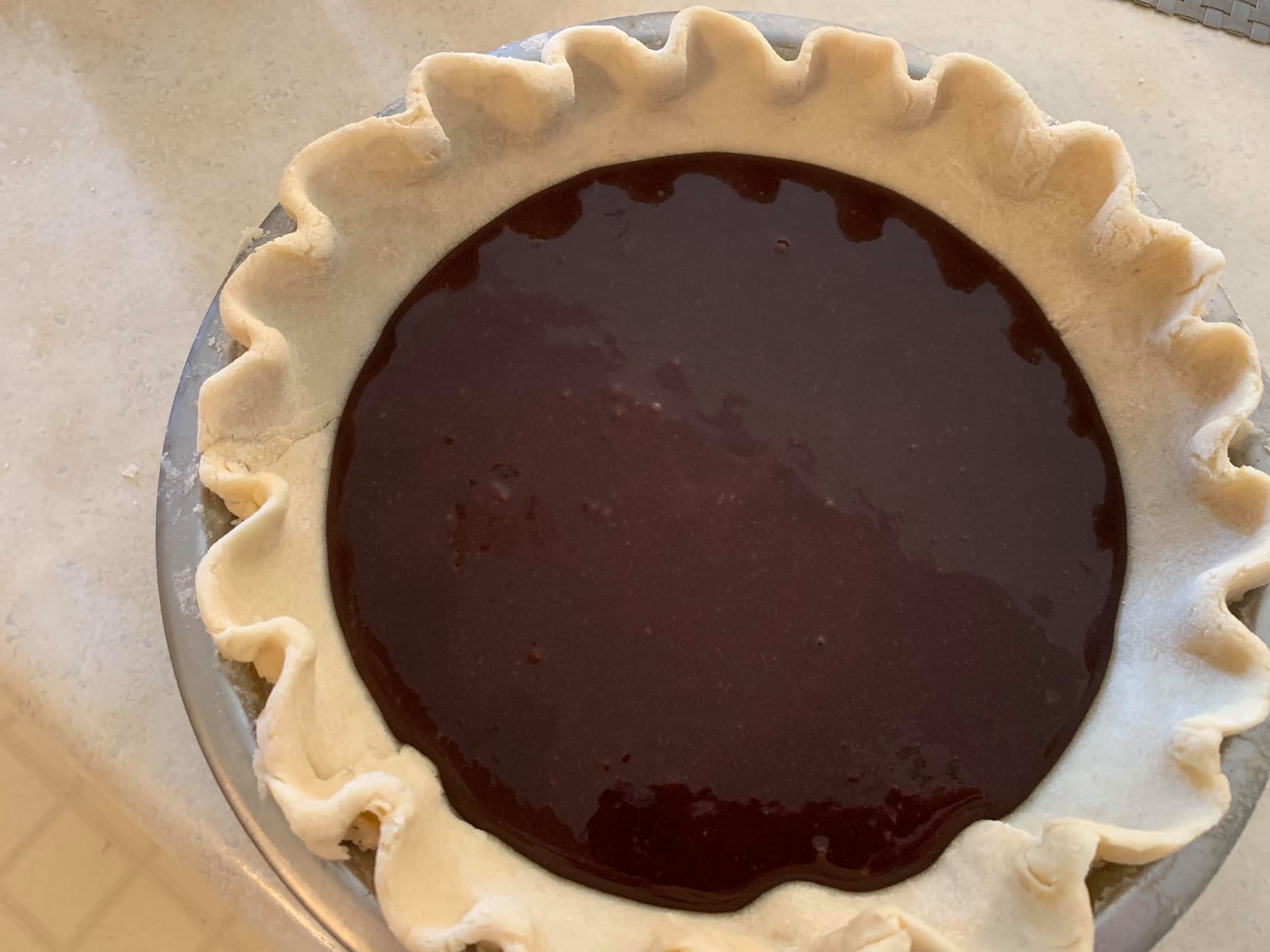 Unbaked chocolate pie filling poured into homemade crust