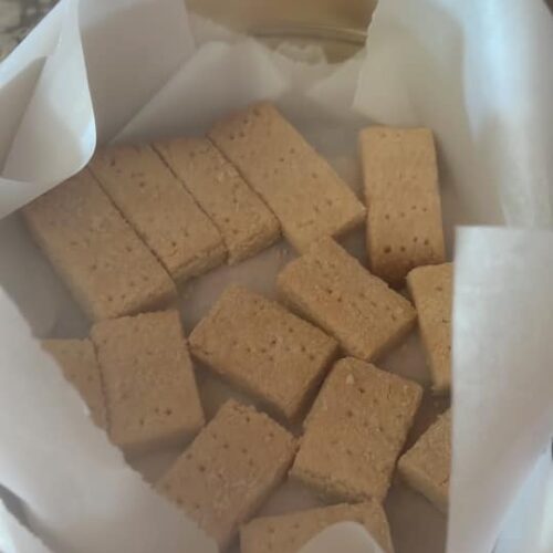 Homemade Scottish shortbread cookies, neatly stacked in a tin, ready for gifting or snacking