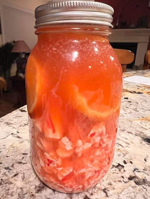 Homemade cough syrup recipe with bourbon, lemon, honey, and peppermint in a mason jar