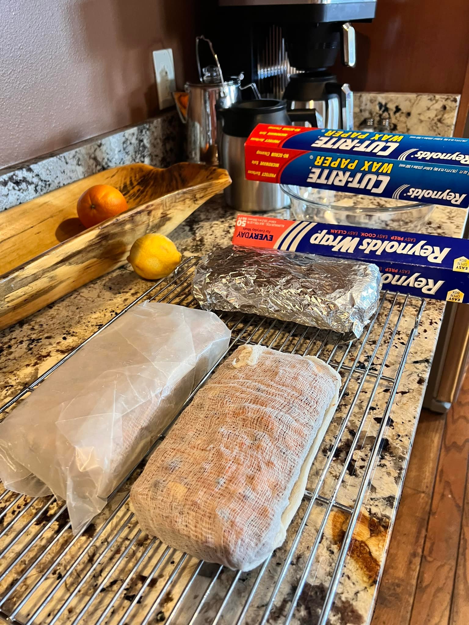 Homemade fruitcake wrapped in brandy-soaked cheesecloth, wax paper, foil, and plastic wrap for storage