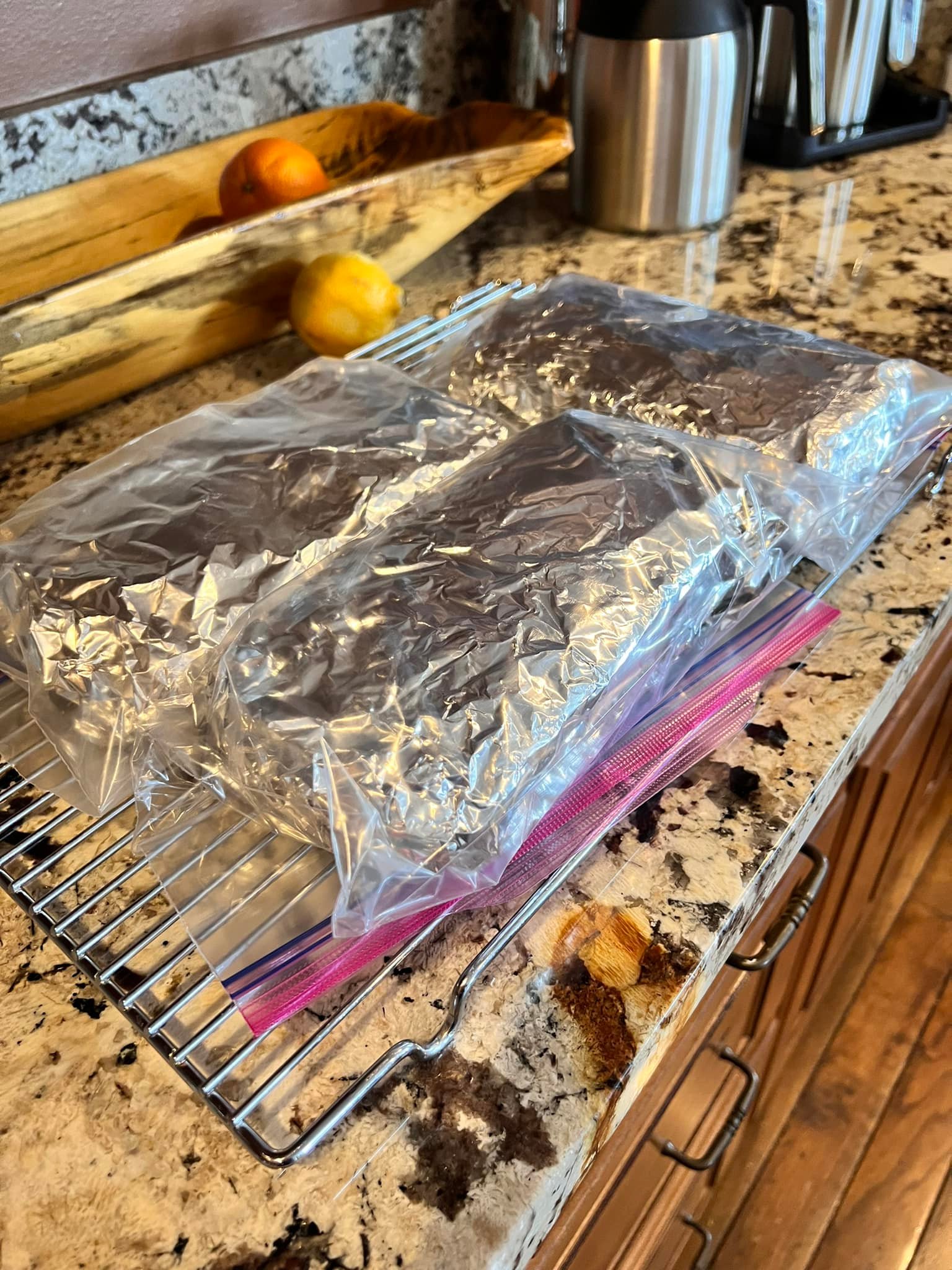 Wrapped homemade fruitcakes sealed in foil and plastic, ready to age in the refrigerator