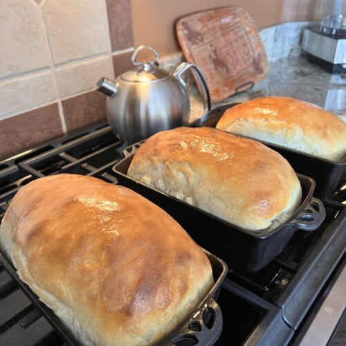 freshly baked sourdough bread loaf sliced on wooden board