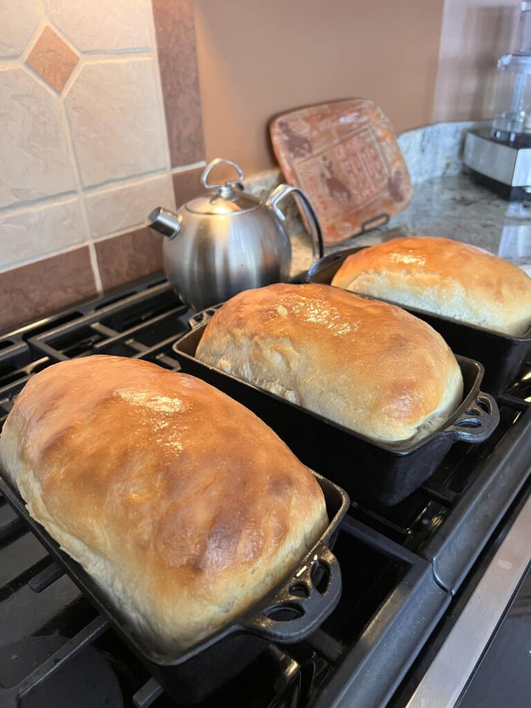 freshly baked sourdough bread loaf sliced on wooden board