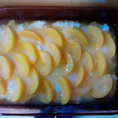 Peach slices neatly layered on batter