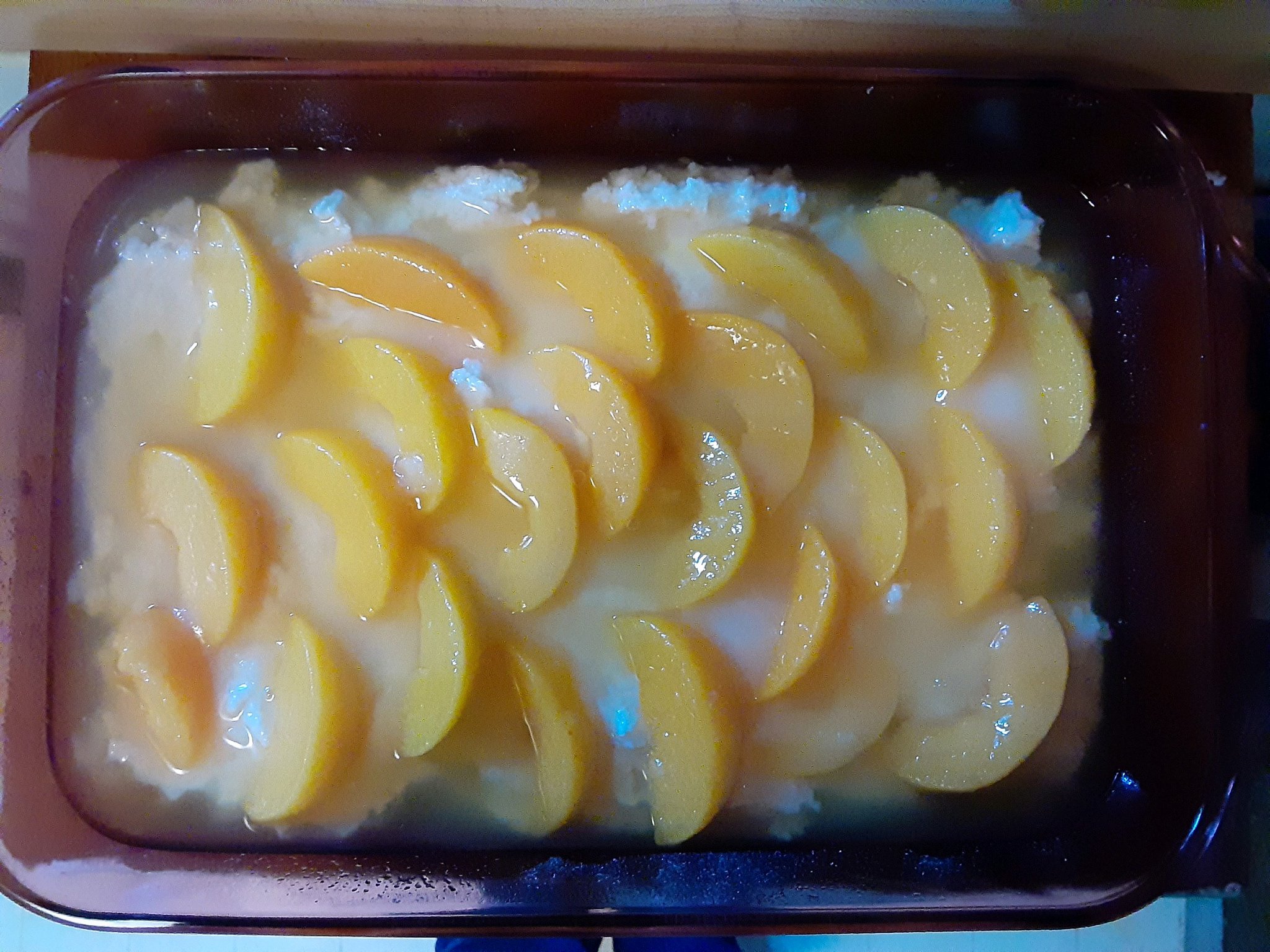 Peach slices neatly layered on batter