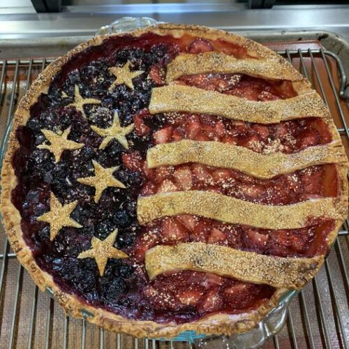 American flag berry pie before baking, stripes and stars raw on crust