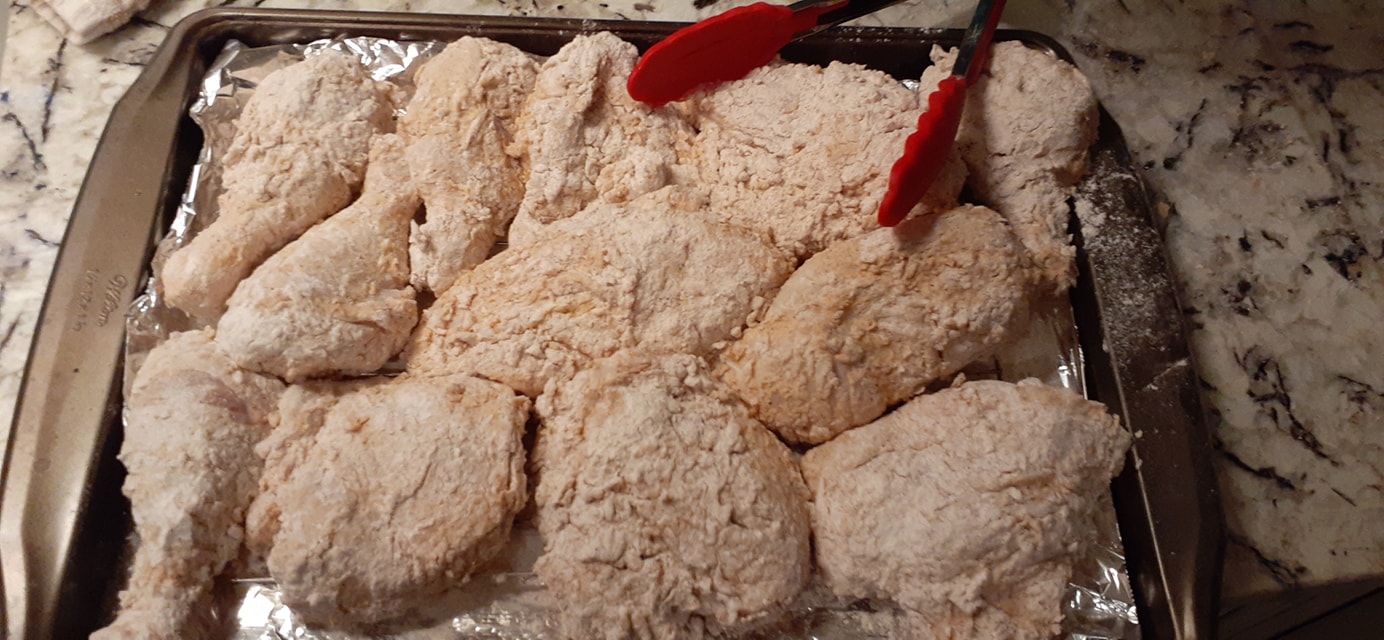 Floured chicken pieces resting on rack before frying – crispy buttermilk fried chicken prep