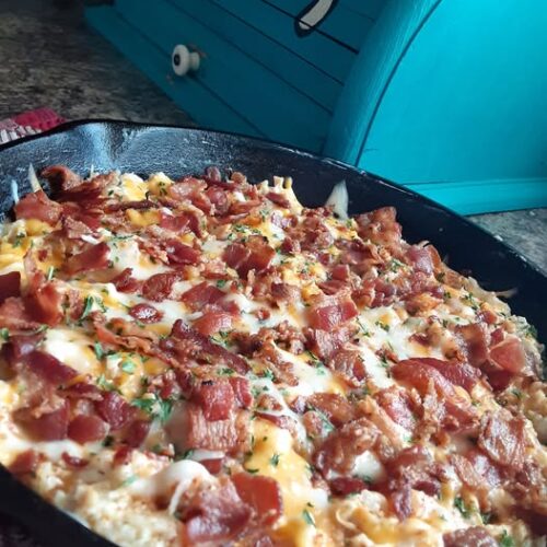 Golden cheesy chipotle cauliflower rice casserole with bacon fresh from oven