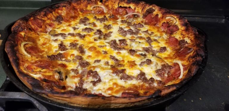 Baked cast iron deep dish pizza golden brown with bubbling cheese and crispy edges