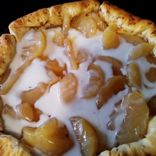 golden baked apple cinnamon roll pie cooling in skillet