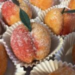 Peach wedding cookies coated in sugar, sparkling on tray