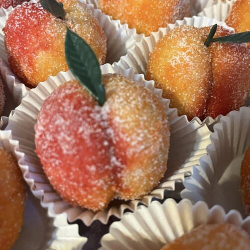 Peach wedding cookies coated in sugar, sparkling on tray