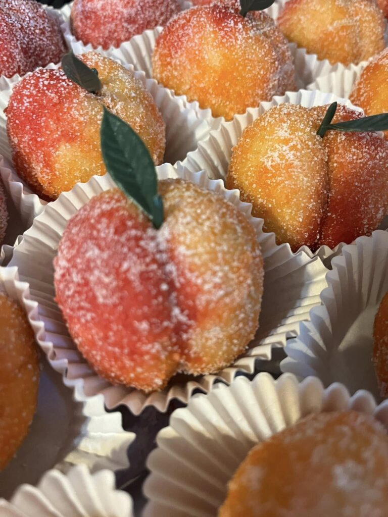 Peach wedding cookies coated in sugar, sparkling on tray