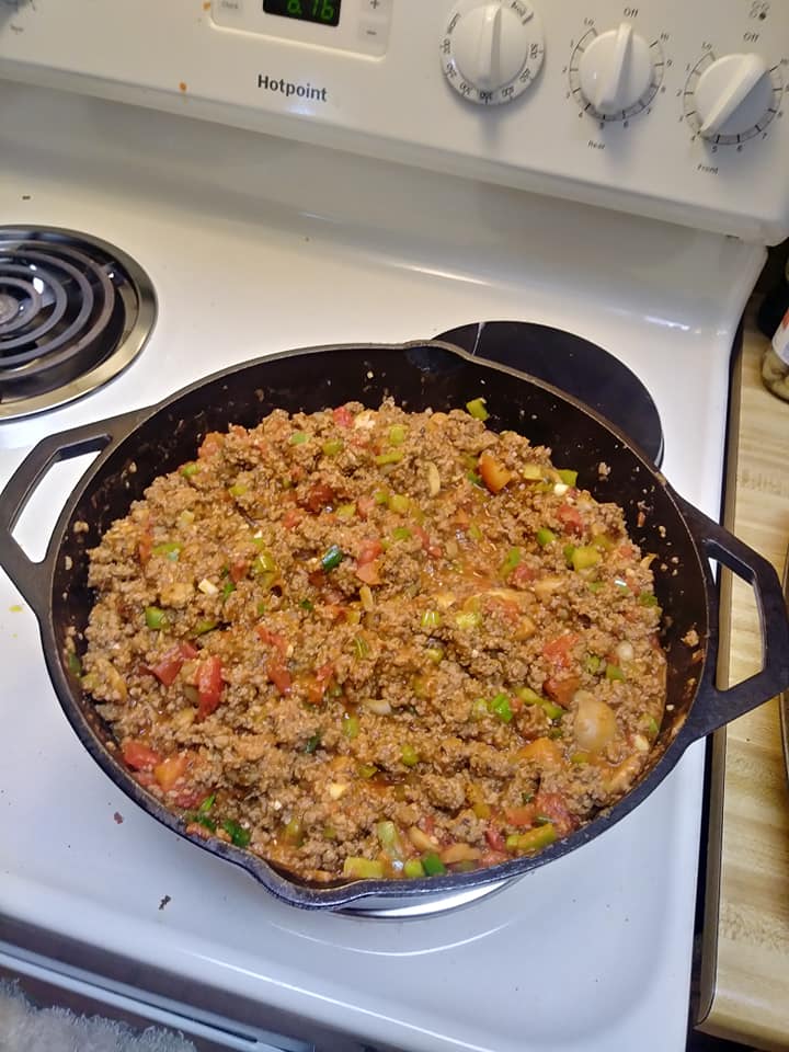 large cast iron pan filled with hearty lasagna meat sauce