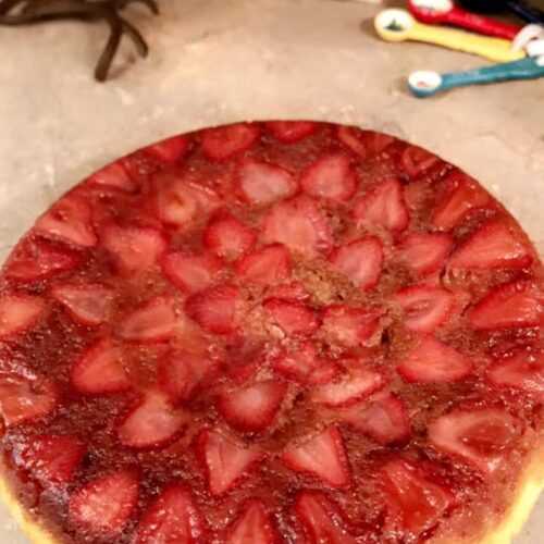 strawberry upside down cake flipped onto plate showing caramelized strawberries