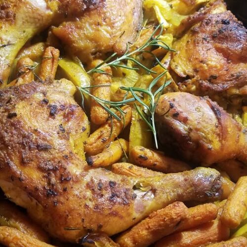 Yellow chicken with apples cast iron recipe fresh from oven with golden skin and roasted carrots.”