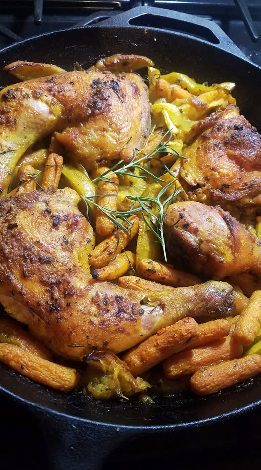 Yellow chicken with apples cast iron recipe fresh from oven with golden skin and roasted carrots.”