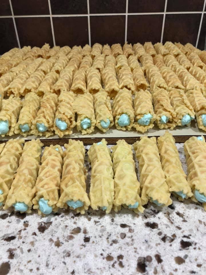 Rolled pizzelle cookies filled with blue vanilla frosting