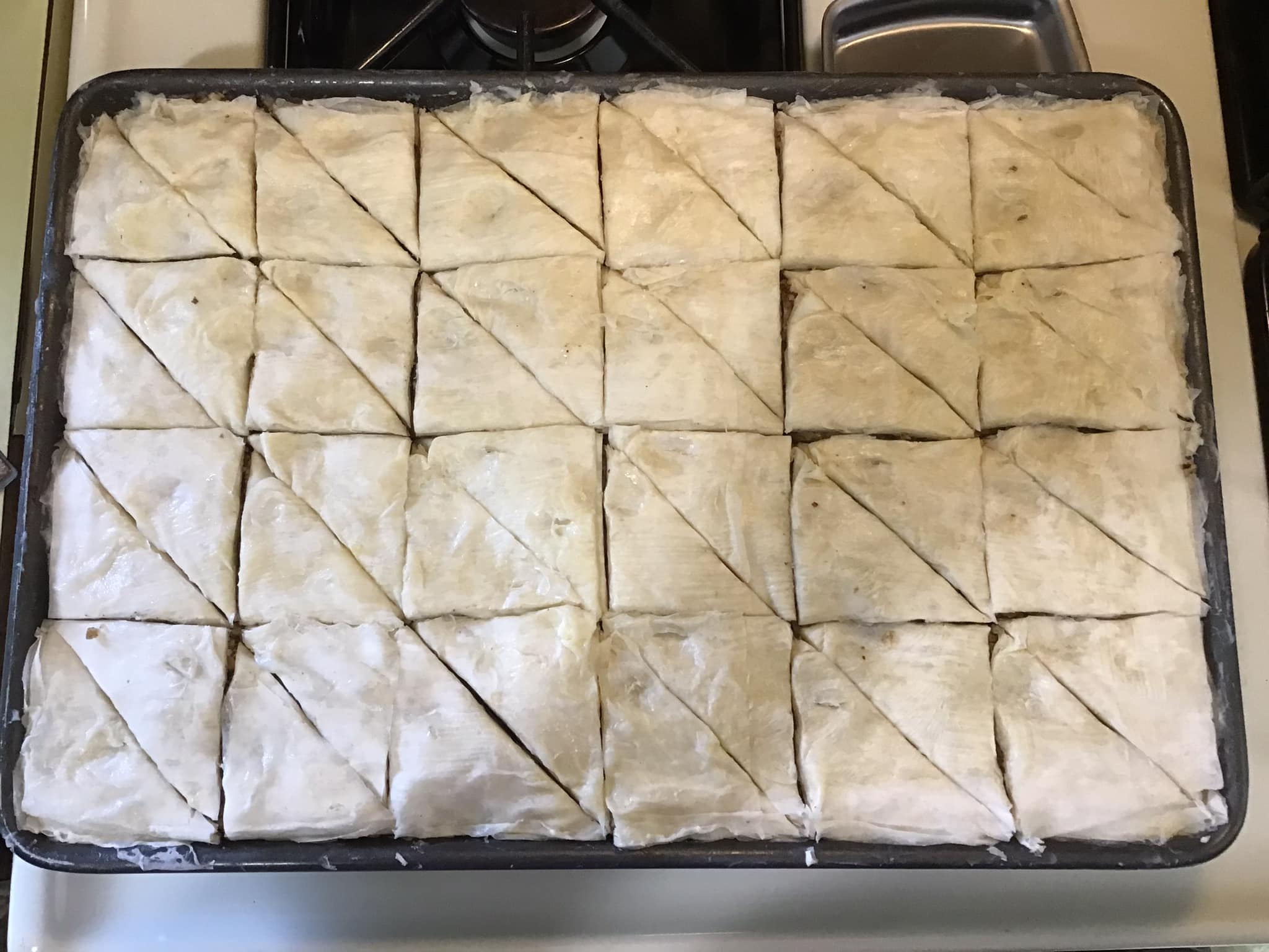 Baklava marked with toothpicks for even cutting before baking
