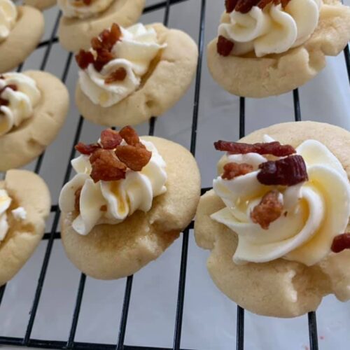 Maple shortbread cookies topped with bourbon frosting, bacon, and maple drizzle