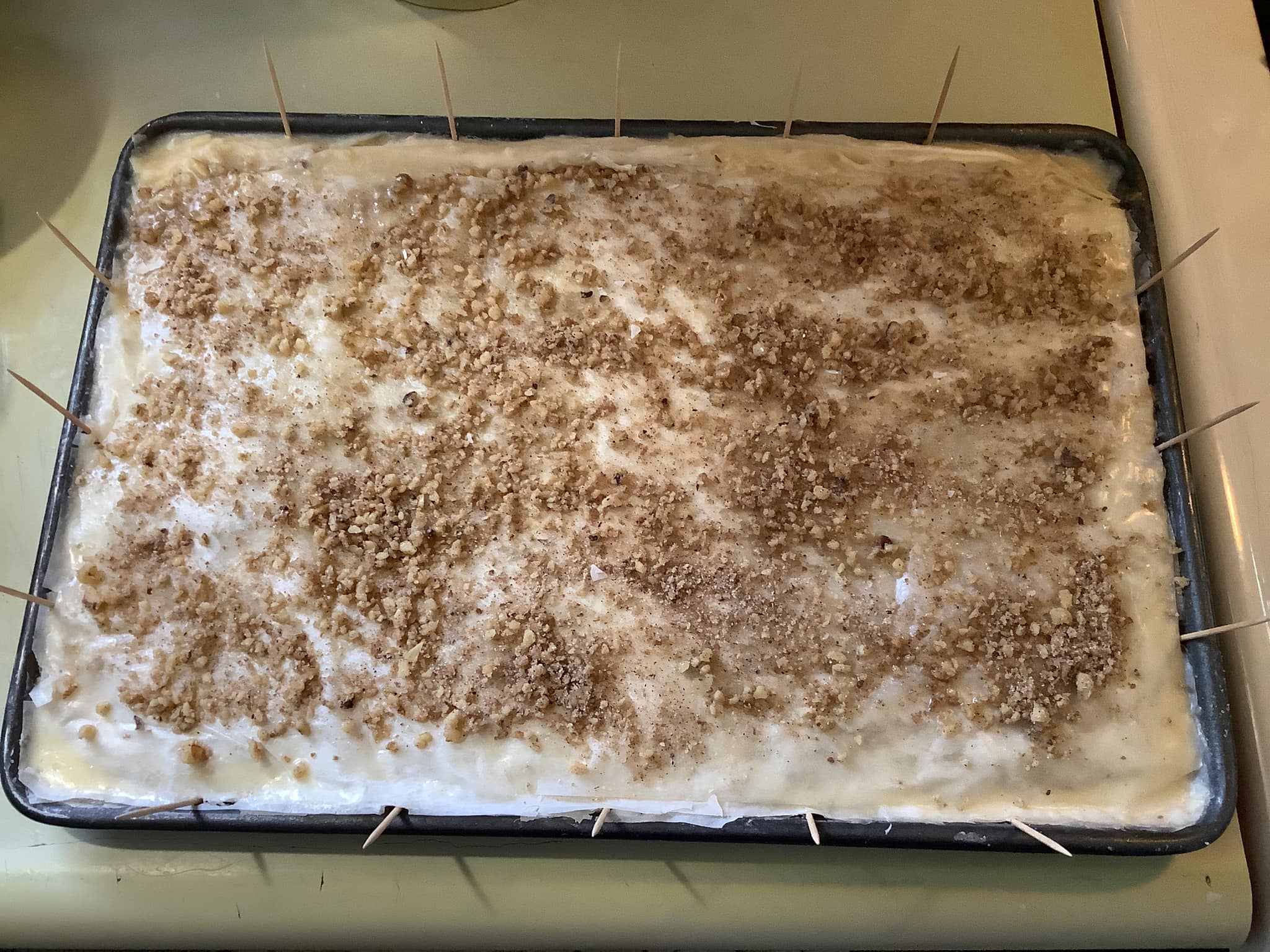Homemade baklava syrup with honey, lemon, and vanilla cooling in a saucepan]